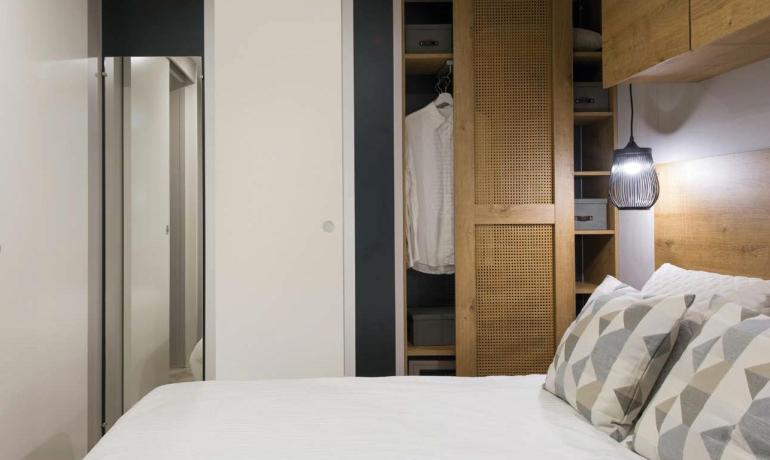 Gemütliches Schlafzimmer mit Kleiderschrank und sanfter Beleuchtung.
