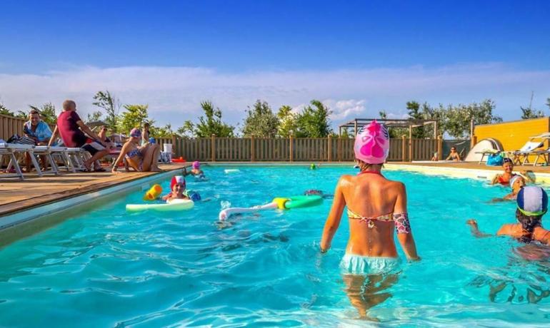 Piscina all'aperto, bambini felici, sole splendente, estate vivace e divertimento.