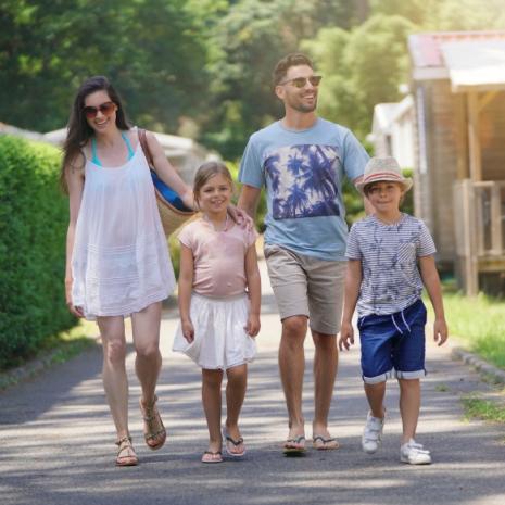 Famiglia felice passeggia all'aperto in una giornata soleggiata.