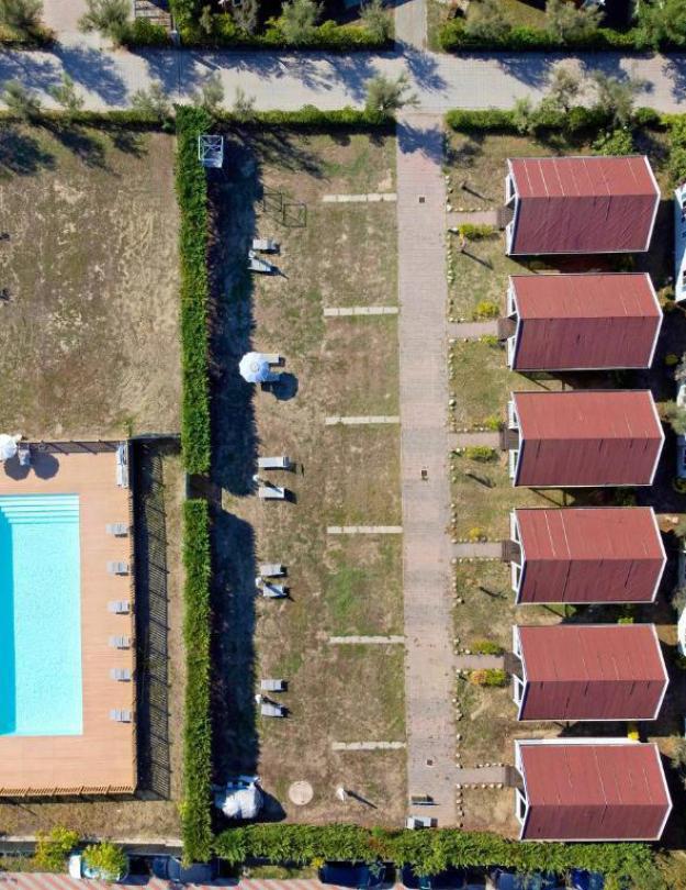 Madre e figlia corrono sulla spiaggia al tramonto, indossando abiti bianchi.