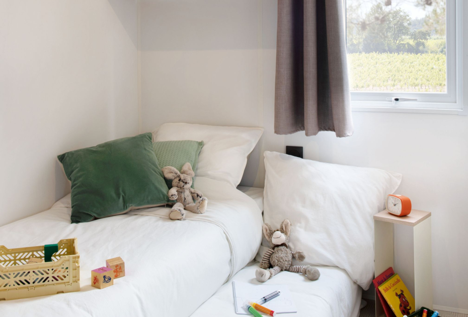 Camera per bambini con letti, giocattoli e decorazioni colorate.
