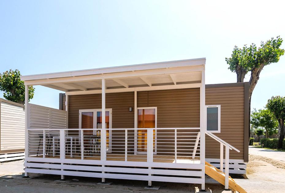 Gemütliches Mobilheim, sonnige Veranda, entspannte Urlaubsatmosphäre.