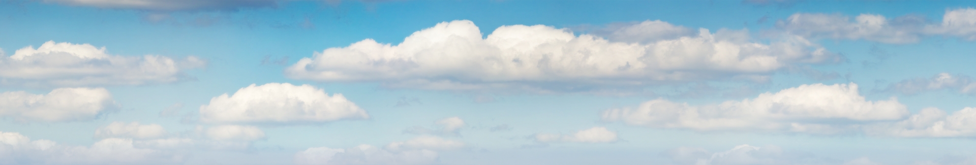 Cielo azzurro con nuvole bianche sparse, creando un'atmosfera serena e tranquilla.